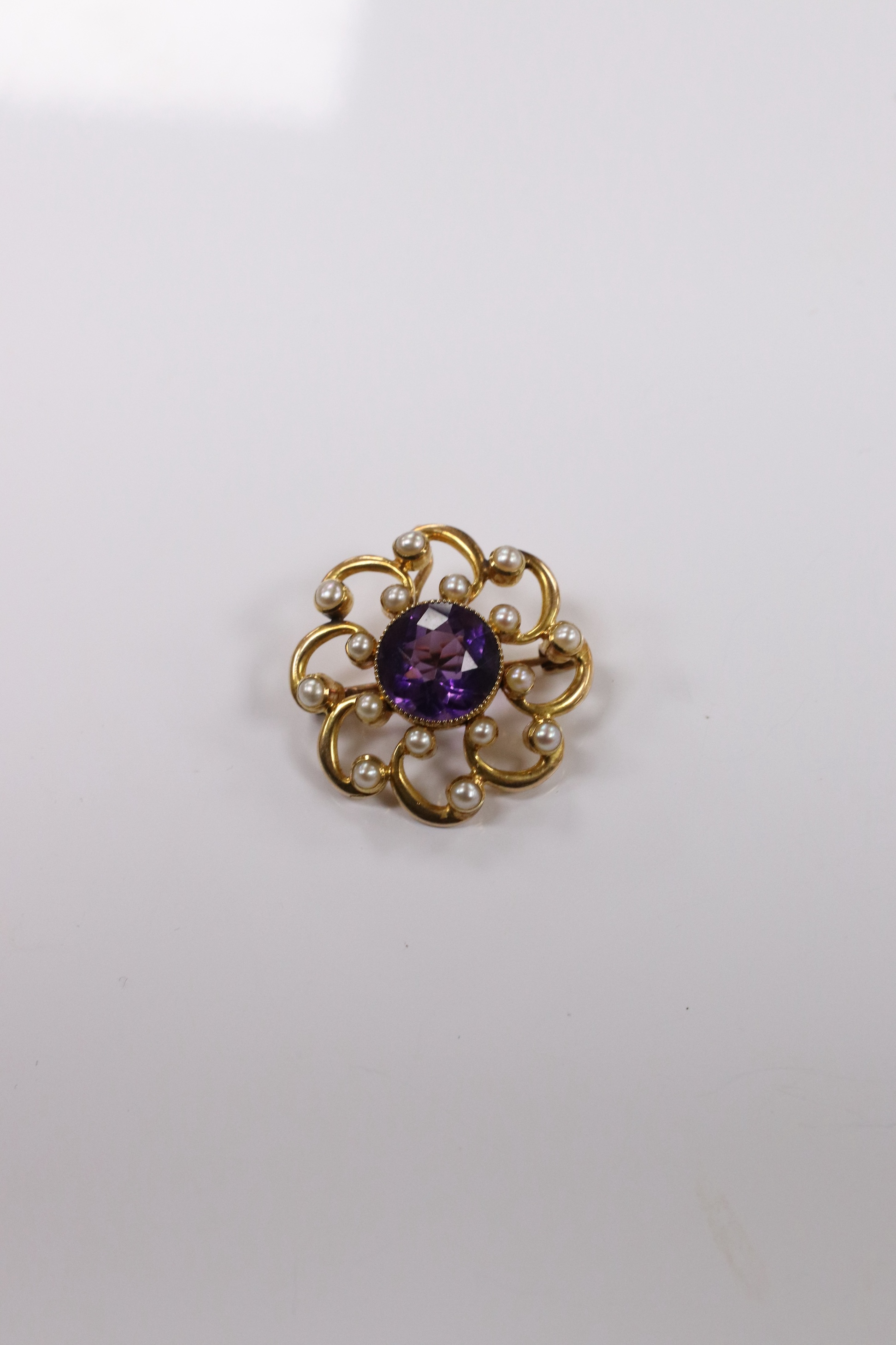 A yellow metal, amethyst and seed pearl cluster set circular pendant brooch, 24mm, gross weight 6.3 grams. Condition - fair to good